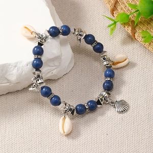 Detail of bohemian ocean style beaded bracelet with blue turquoise and cowrie shell charms