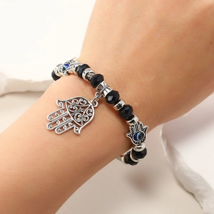 Vista macro de amuletos de mano de Fátima y ojo turco en una pulsera de cuentas