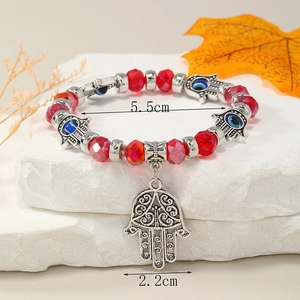 Detalle de la pulsera mano de Fátima con cuentas rojas talladas y medidas