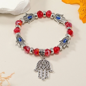 Primer plano detallado de pulsera de cuentas rojas con Mano de Fátima y dijes de Ojo Turco