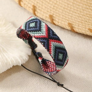 Macro shot of colorful woven Bohemian bracelet featuring vintage geometric diamond patterns