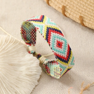 Macro detail of handmade bohemian woven bracelet with colorful geometric diamond patterns
