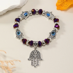 Macro detallado de la mano de Fátima y cuentas de ojo turco en una pulsera amuleto