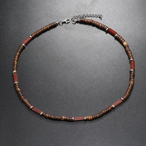Dettaglio della collana di perle di cocco con accenti di pietre rosse e chiusura a moschettone