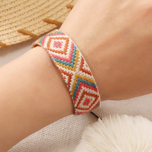Detail of bohemian handmade woven bracelet with colorful geometric patterns on a wrist