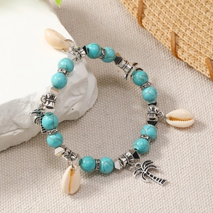 Detail of Bohemian turquoise bead bracelet with natural shells and palm tree charms