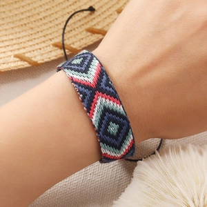 Detail of bohemian handwoven bracelet featuring colorful geometric patterns and adjustable cord