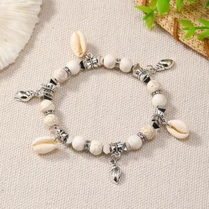 Detail of Bohemian beaded bracelet with white marble beads and silver sea shell charms
