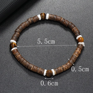 Détails d'un bracelet en noix de coco avec des perles de turquoise et d'oeil de tigre