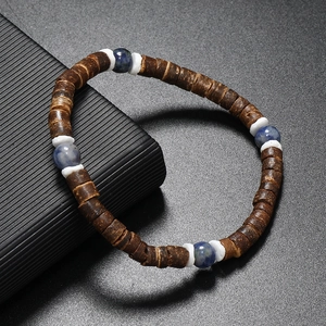 Détail de perles en noix de coco, turquoise et coquillage sur un bracelet perlé minimaliste