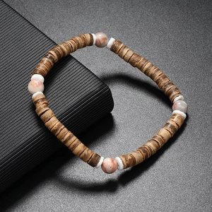 Détail de perles en noix de coco et pierres marbrées sur un bracelet de style bohème