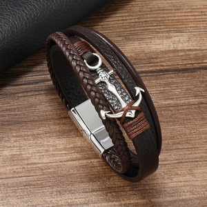 Détail d'un bracelet multicouche en cuir marron avec ancre argentée et fermoir magnétique