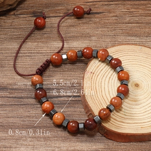 Détail de perles en bois rouge et de cubes d'hématite sur un bracelet de surfeur