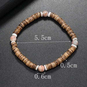Détail des perles en noix de coco et de l'entretoise turquoise sur le bracelet perlé