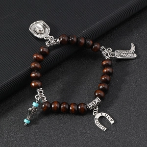 Detail of western cowboy charms including boots and lucky horseshoe on beaded bracelet