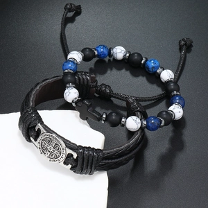 Detail van retro kralenarmband met kruis en geweven lederen polsband met religieuze penning