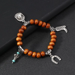 Detail view of western style wood bead bracelet with cowboy hat and boots silver charms