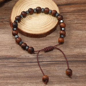 Gros plan du bracelet en perles de bois avec détails en métal et cordon tressé réglable