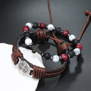 Detail van religieuze armbandenset met bruin leer en medaille van de Heilige Benedictus