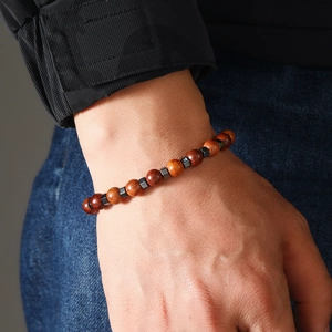 Détail de perles en bois et carrés d'hématite sur un bracelet de surfeur pour homme