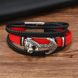 Macro shot of multi-layer leather bracelet with tiger head charm and red strap detail
