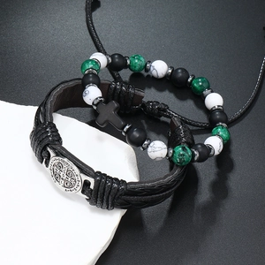 Macro detail van de vintage leren armbandenset met kruis en Sint-Benedictus medaille