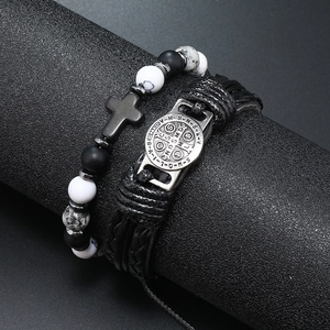 Detailopname van retro leren gevlochten armband en kralenarmband met kruis