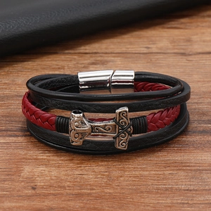 Detailed macro view of black and red braided leather bracelet with silver Thor's Hammer