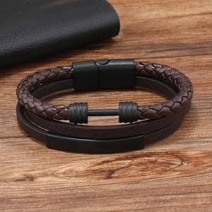 Macro shot of men's leather bracelet with dumbbell metal charm on a wooden background