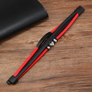 Detail of red and black woven leather bracelet with silver lion head and magnetic clasp
