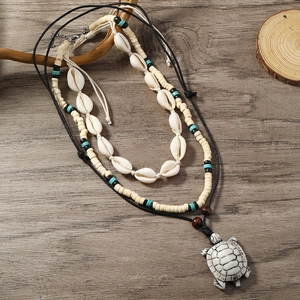 Detail of multi-layer shell necklace with turtle pendant and sea style beads