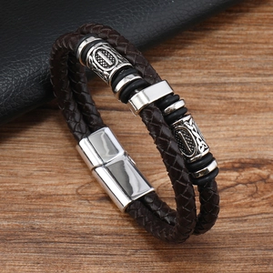 Gros plan d'un bracelet en cuir marron double couche avec des perles tribales argentées