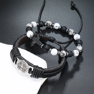 Detail van kruishanger en Sint-Benedictusmedaille op leren en kralenarmband