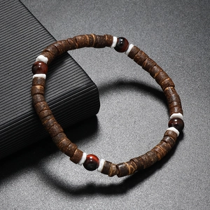 Vue macro de perles en coque de coco avec œil de tigre rouge et entretoises blanches