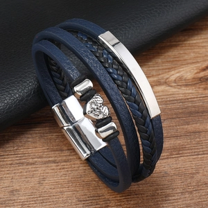 Detail view of multi-layer navy woven leather bracelet with skull charm and magnetic clasp