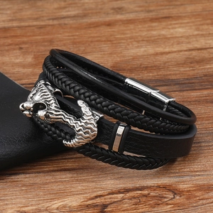Detail of multi-layer braided leather bracelet with silver wolf head and magnetic clasp