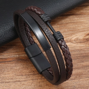 Detail of male braided leather bracelet with matte black metal plates and magnetic clasp