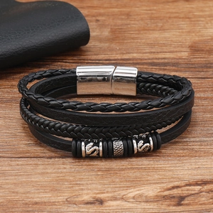 Macro view of men's leather bracelet with dragon motif metal ring and magnetic clasp