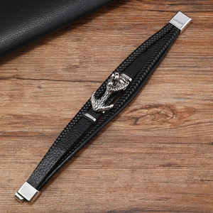 Close-up of multilayer braided leather bracelet with vintage silver anchor charm and clasp