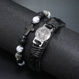 Detail van de Benedictus-medaille op de leren armband en kralenarmband met kruisje