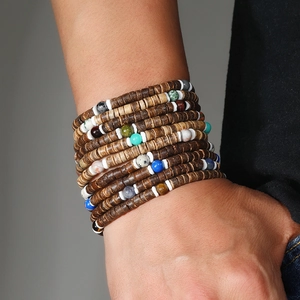 Détail d'un bracelet bohème multicouche avec des perles en noix de coco et turquoises
