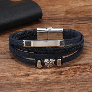 Close-up of multilayer woven leather bracelet with heart wing pendant and magnetic clasp