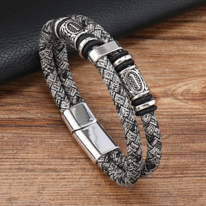 Détail d'un bracelet en cuir tressé noir pour homme avec fermoir magnétique et gravures