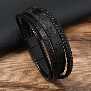 Détail du bracelet multicouche en cuir avec motif crâne et fermoir magnétique noir