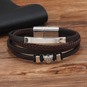 Detail view of multi-layer brown braided leather bracelet with heart charm and magnetic clasp