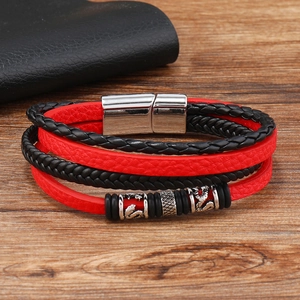 Detail of multi-layer leather bracelet with polished silver magnetic clasp and charms