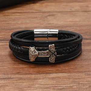 Close-up of a multi-layer black leather braided bracelet with a silver Thor's Hammer charm