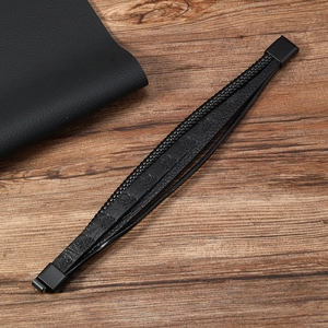 Détail d'un bracelet multicouche en cuir noir avec motif de crâne et fermoir magnétique