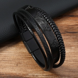Macro shot of men's leather bracelet showing woven straps and bull head buckle detail