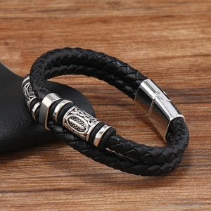 Détail du bracelet double en cuir tressé noir avec éléments décoratifs en métal argenté